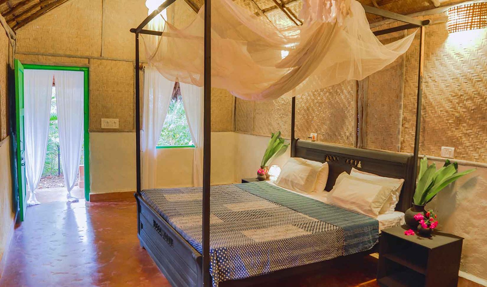 A natural SWAN cottage with woven walls and a mosquito-netted bed