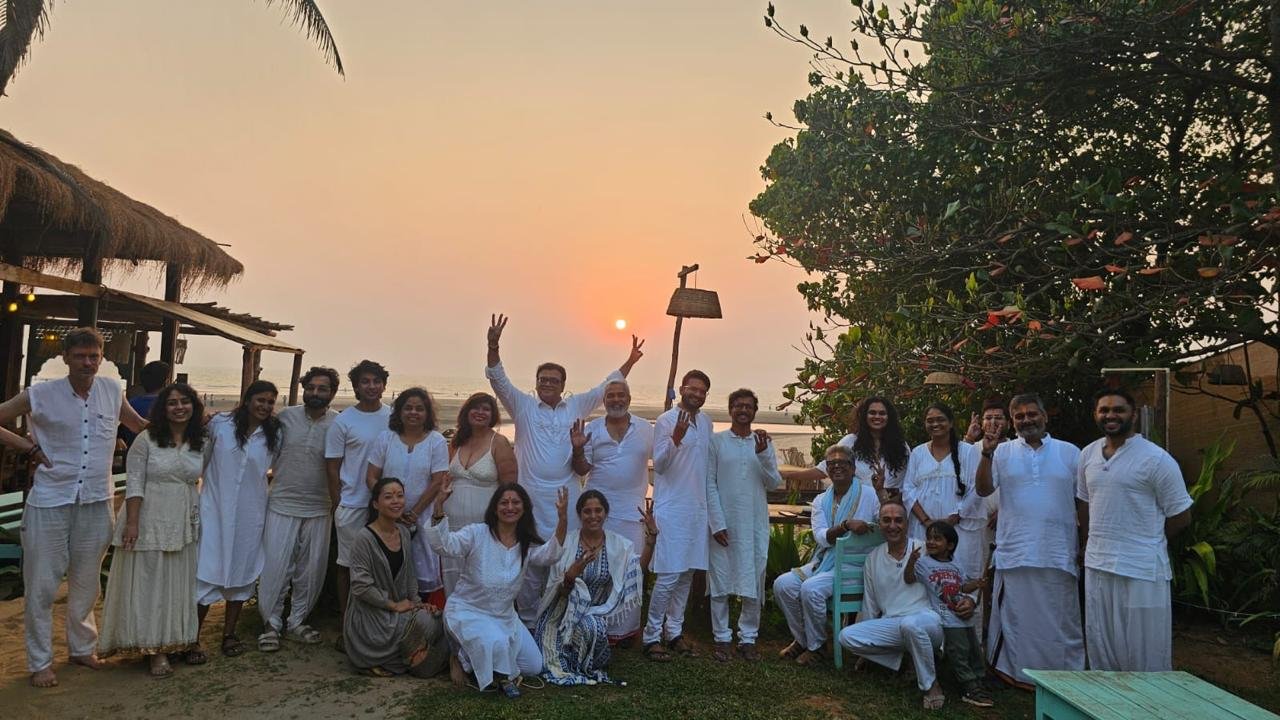 The Trika community gathered together beside the sea at sunset